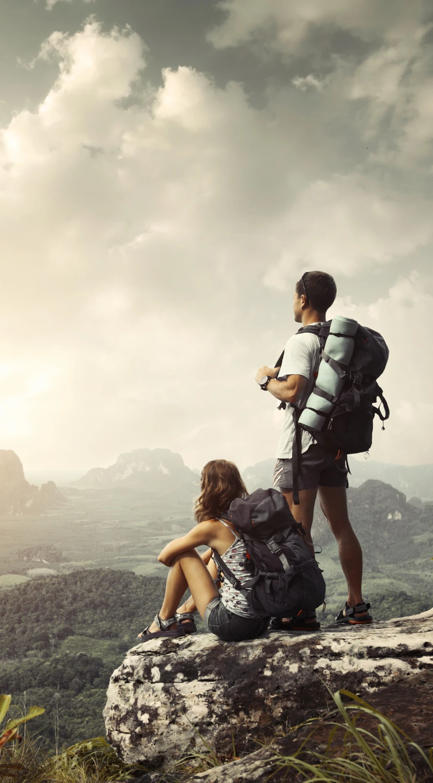 Para podróżników odpoczywa i podziwia widoki po zdobyciu szczytu