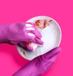 Mycie zabrudzonego talerza gąbką przy użyciu koncentratu Pinky NanoWash
